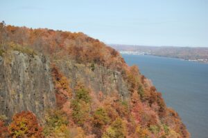 A view of a cliff with a body of waterin the background